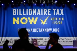 Large blue banner reading Billionaire Tax Now, with a checkbox and Vote Yes 11/3/26, viewed over the silhouettes of audience members.